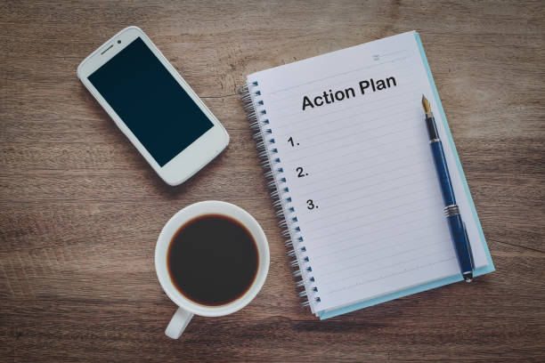 istock Action Plan text on book note with cup of coffee, pen. 1137965394