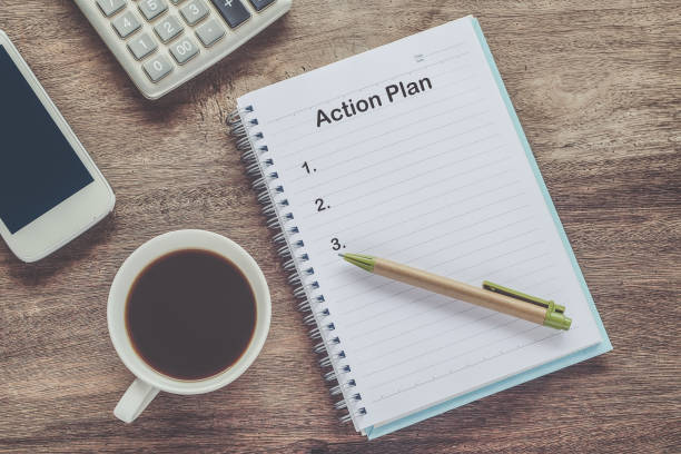 istock Action Plan text on book note with cup of coffee, pen. 1137965395