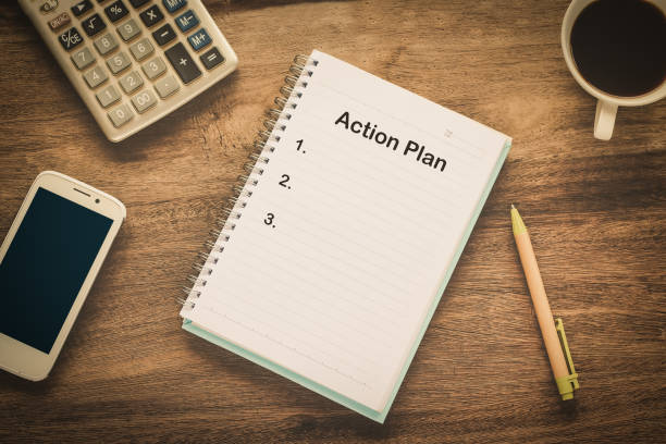 istock Action Plan text on book note with cup of coffee, pen. 1137965396