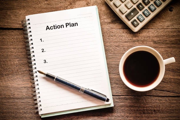 istock Action Plan text on book note with cup of coffee, pen. 1137965398