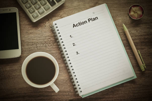 istock Action Plan text on book note with cup of coffee, pen. 1137965401