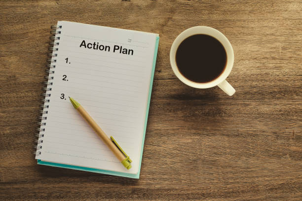 istock Action Plan text on book note with cup of coffee, pen. 1137965402