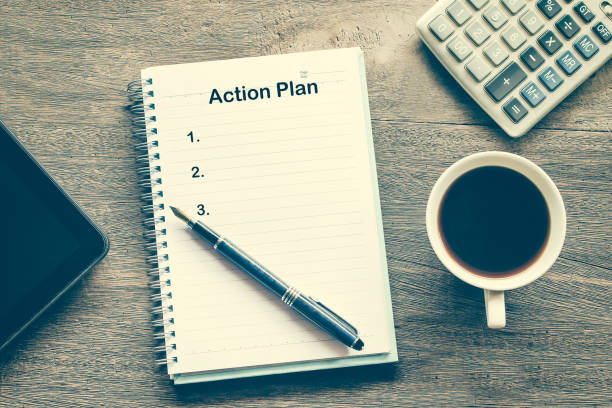 istock Action Plan text on book note with cup of coffee, pen. 1137965407