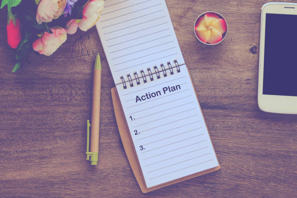 istock Action Plan text on book note with cup of coffee, pen. 1137965412