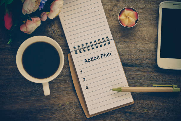 istock Action Plan text on book note with cup of coffee, pen. 1137965417