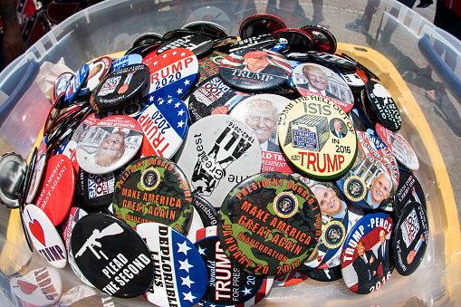 Helen, GA, USA - June 2, 2018:  As assortment of Donald Trump campaign and conservative political buttons sits on display at the Trump Shop, a popup outdoor store selling Trump apparel and merchandise in a parking lot on June 2, 2018 in Helen, GA.