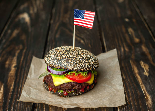 istock Beef hamburger with black bun with lettuce and ketchup served on a rustic wooden table 1137972583