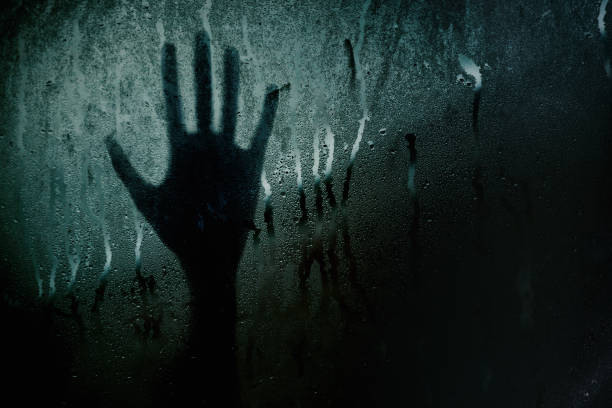 istock Silhouette Blur hand touching glass or window 1137972686
