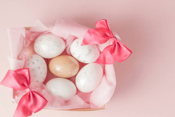 istock White Easter eggs in a nest on pink background. Design pastel tone in minimal flat lay 1137972737