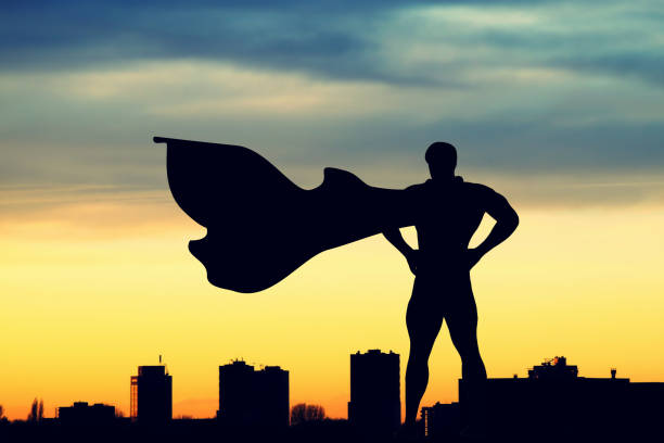 Superhero silhouette back view over watching the city at sunset or sunrise for security and defense the city from crime and illegal activities