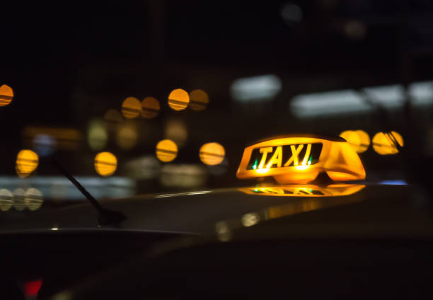 letrero iluminado taxi en el techo del coche - taxi fotografías e imágenes de stock