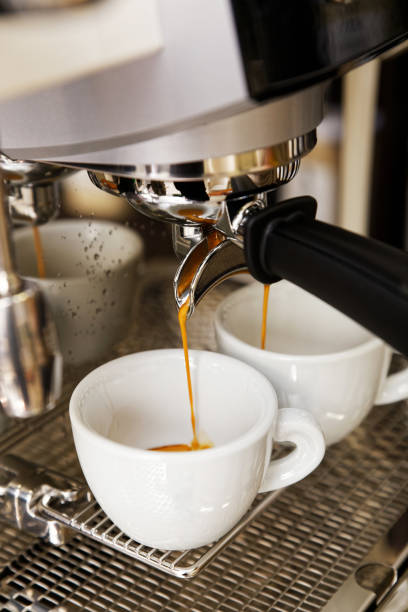 istock Coffee brewing in coffee machine. Espresso pouring in two cups. 1137973533
