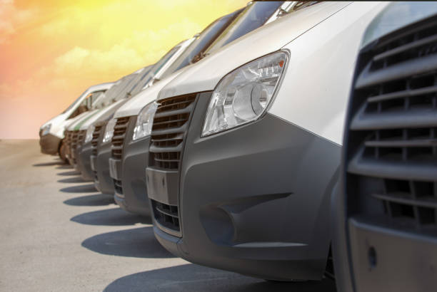 istock White mini-buses in a row for sale or rent. 1137973546