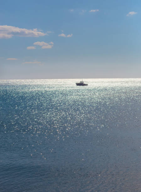 istock single boat in the distance under moonlight 1137974307