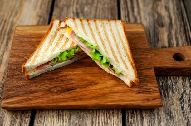istock Two sandwiches on a cutting board on a wooden background in a rustic style. view from above 1137975305