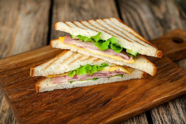 istock Two sandwiches on a cutting board on a wooden background in a rustic style. view from above 1137975395
