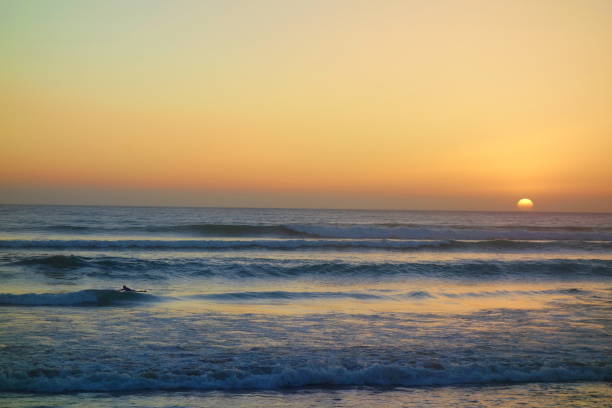 Sunset in Taghazout with a surfer in the background, Morocco, Africa