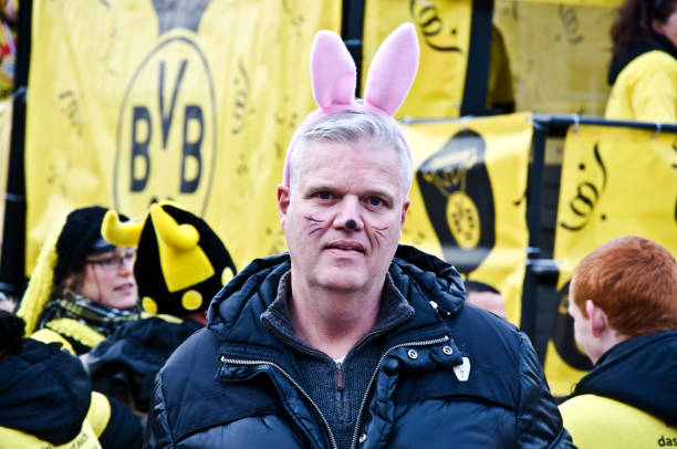 dortmunder rosenmontag en kampstrasse: hombre espectador/turista con orejas de conejo disfrutando borussia dortmund fc (bvb) stand en dortmund alemania rose lunes desfile-punto culminante de la alemana karneval, celebrada en el shrove lunes - germany carnival spectator group of people fotografías e imágenes de stock