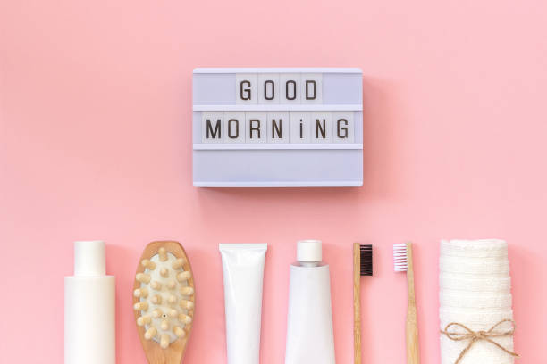 Light box text Good morning and set of cosmetics products and tools for shower or bath on pink background. Concept female morning body care, face, teeth for beauty and health. Template Top view stock photo