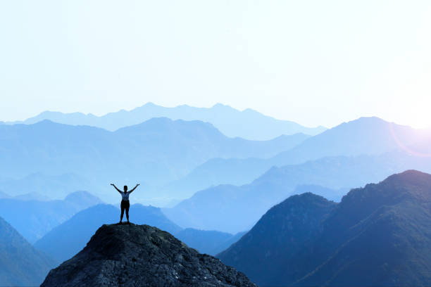 female hiker celebrating success - arms outstretched fotos imagens e fotografias de stock