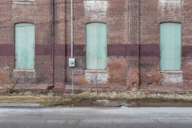 istock Light green boarded up windows of an abandoned red brick factory 1137980067