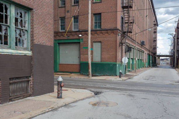 scène de rue vintage avec des entrepôts de briques rouges abandonnés dans une zone industrielle déprimée - us coin photos et images de collection