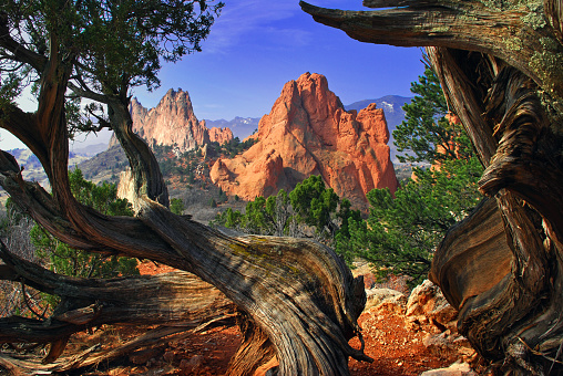 Dramatic clouds and Massive red sandstone rock formations at entry to the Garden of the Gods in Colorado Springs, Colorado in western USA of North America. Pikes Peak in the background.