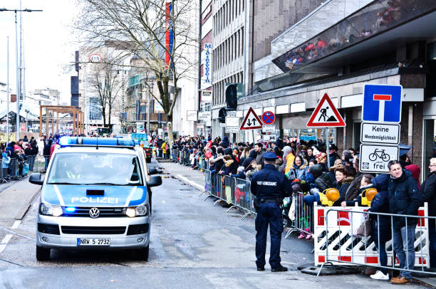 pattuglia della polizia tedesca dortmunder rosenmontag: spettatori e turisti in fila per strada godendosi i treni della parata del lunedì delle rose di dortmund germania - momento clou del karneval tedesco, tenutosi il lunedì dello shrove prima del merco - protest editorial people travel locations foto e immagini stock