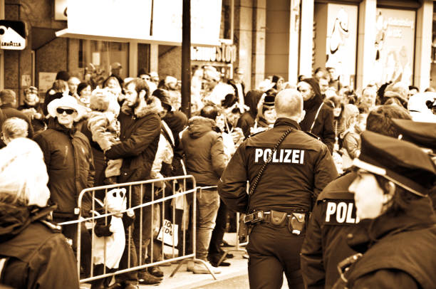 patrulla de policía alemana dortmunder rosenmontag: espectadores y turistas alinean la calle disfrutando de los trenes de desfile del lunes rosa de dortmund alemania-punto culminante de la karneval alemana, celebrada en el shrove lunes antes del miércole - germany carnival spectator group of people fotografías e imágenes de stock