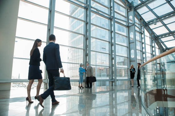 Business people walking Business people walking on a modern walkway in office building lobby stock pictures, royalty-free photos & images