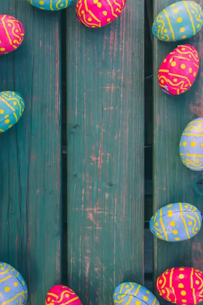 Colored easter eggs in a bowl standing on a green wooden bench, Amsterdam the Netherlands, 23 march 2019