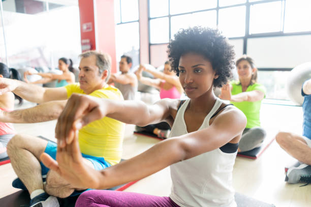 istock Diverse group of people at the gym stretching their hands while sitting on floor 1137990912