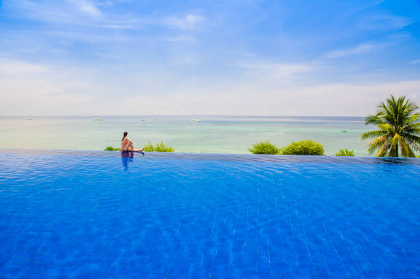 istock Young woman sitting on the Infinity pool 1137991207