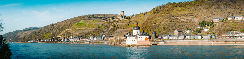 Beautiful view of the historic town of Kaub with famous Burg Pfalzgrafenstein along Rhine river on a scenic sunny day with blue sky in spring, Rheinland-Pfalz, Germany