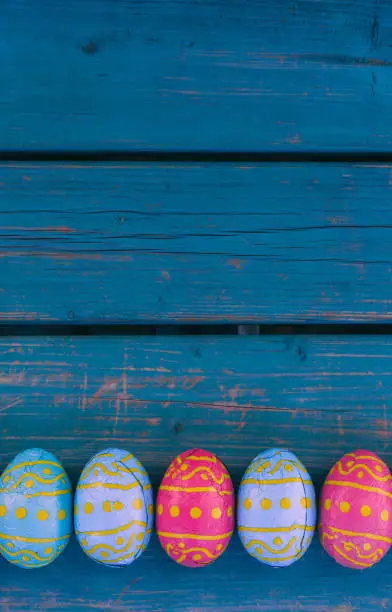 Colored easter eggs in a bowl standing on a blue wooden bench, Amsterdam the Netherlands, 23 march 2019