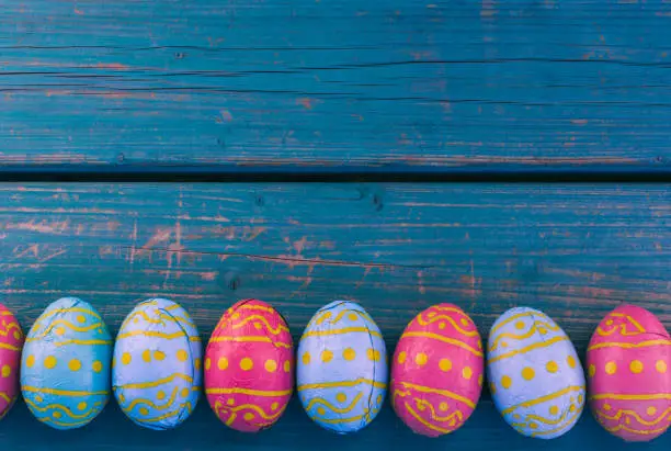 Colored easter eggs in a bowl standing on a blue wooden bench, Amsterdam the Netherlands, 23 march 2019