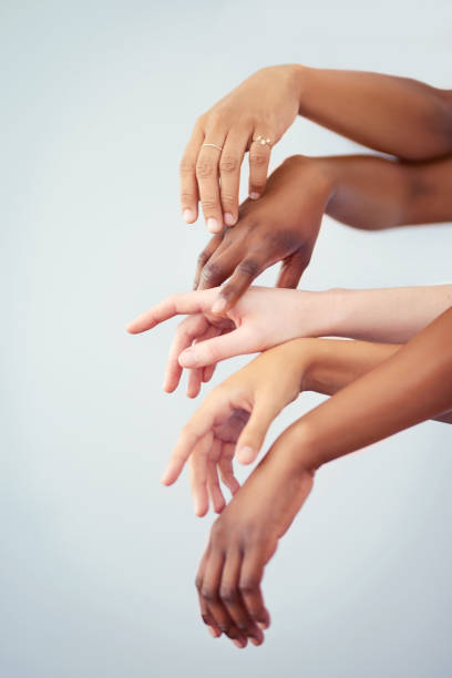 Skin tone doesn't define beauty Cropped studio shot of a group of women touching hands against a gray background skin tones stock pictures, royalty-free photos & images