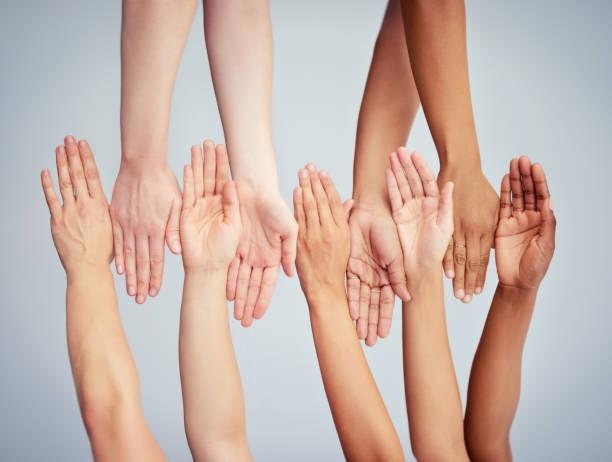 Acceptance is in the hands of all of us Cropped studio shot of a group of women stacking their hands against a gray background melanin photos stock pictures, royalty-free photos & images