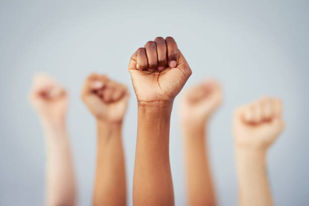 Put the power back in your hands Cropped studio shot of a group of women raising their fists in solidarity against a gray background girl power photos stock pictures, royalty-free photos & images