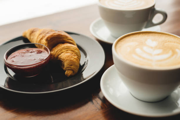 istock Two cups of cappuccino and croissant with jam 1137994126