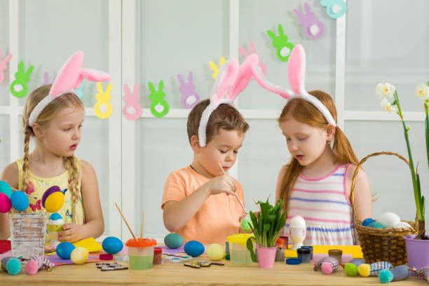 istock cute kids painting Easter eggs at home. 1137994814