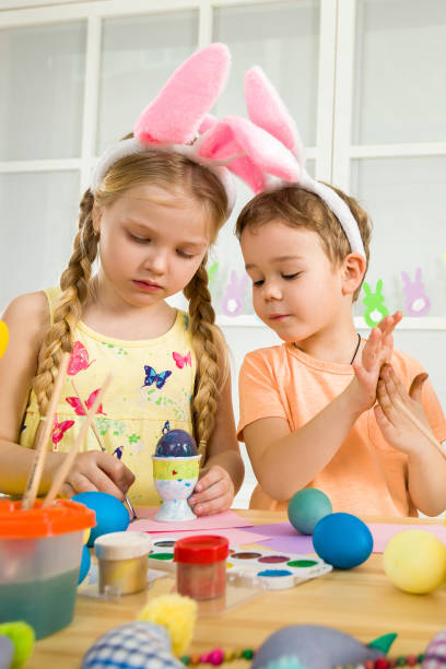 istock cute kids painting Easter eggs at home. 1137994919