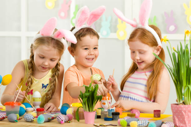 istock cute kids painting Easter eggs at home. 1137995456