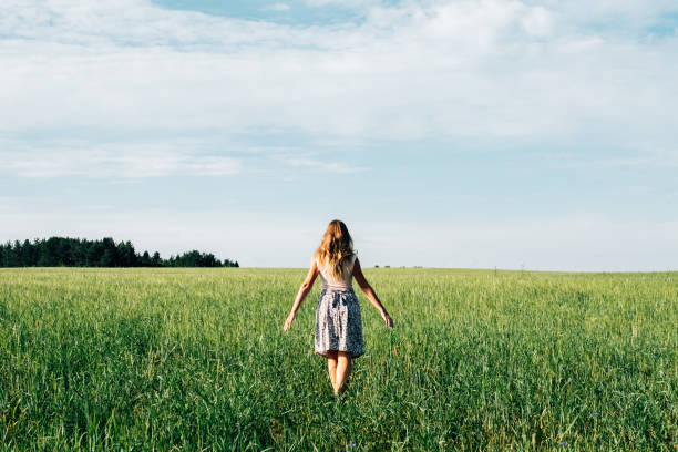 jeune femme dans le champ de blé. vue de l'arrière - footpath field nature contemplation photos et images de collection