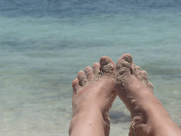 istock Bare foot female beach closeup sea copy space 1137999388