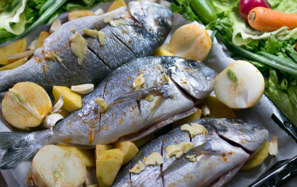 istock bream fish on a baking tray lined with potatoes and onions 1137999760