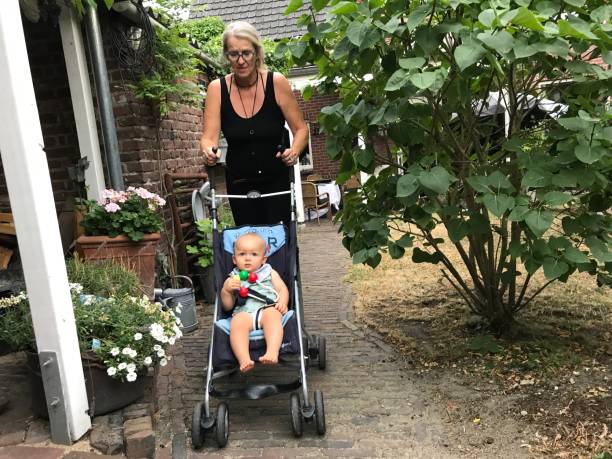 Young active father with kids in double stroller in a park. Dad with twin pram walking in the forest.  Parent with twins, son and daughter, hiking in the woods. Outdoor fun for family with children.