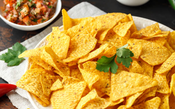 istock Tortilla nachos chips with cheese sauce, guacamole and tomatoes salsa dip. lime. chilli pepper. 1138004548