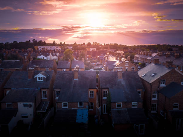 de zon stijgt boven een traditioneel brits huisvestingslandgoed met platteland op de achtergrond. - areal stockfoto's en -beelden
