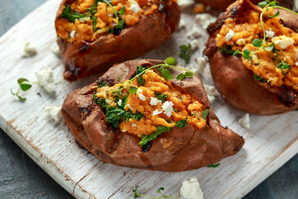 gebraden zoete aardappel gevuld met feta kaas en boerenkool. gezonde voeding - zoete aardappel fotos stockfoto's en -beelden